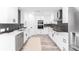 Bright kitchen features white cabinets, stainless steel appliances, black hardware, and subway tile backsplash at 4164 W Eldorado Pl, Denver, CO 80236