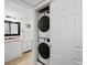 Clean bathroom with stacked washer and dryer in the closet, updated vanity and black framed mirror at 7665 E Eastman Ave # 110, Denver, CO 80231