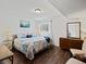 Bright bedroom featuring hardwood floors, a comfortable bed, and ample natural light from the window at 7665 E Eastman Ave # 110, Denver, CO 80231