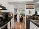 Modern kitchen showcasing hardwood flooring, sleek countertops, and views into adjacent living spaces at 7665 E Eastman Ave # 110, Denver, CO 80231