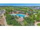 Aerial shot of a community pool, hot tub, and clubhouse surrounded by mature trees and landscaping at 1901 Corner Rock Ln, Castle Rock, CO 80108