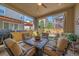 Covered patio with comfortable seating, a ceiling fan, and views of the beautifully landscaped backyard at 1901 Corner Rock Ln, Castle Rock, CO 80108