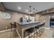 Basement wet bar with granite countertops, modern lighting, barstool seating, wine fridge, and open shelving at 1901 Corner Rock Ln, Castle Rock, CO 80108