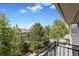 Balcony view overlooking lush greenery, mature trees, and blue skies, perfect for enjoying the outdoors at 14058 E Temple Dr, Aurora, CO 80015