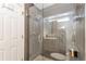 Modern shower featuring sleek tilework, glass door, built-in bench, and recessed lighting at 14058 E Temple Dr, Aurora, CO 80015