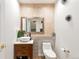 Stylish powder room featuring modern vanity, decorative mirror, unique wall decor, and a sleek toilet at 14058 E Temple Dr, Aurora, CO 80015