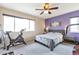Bedroom with purple accent wall, exercise equipment, and bright natural light at 14058 E Temple Dr, Aurora, CO 80015