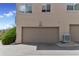 Exterior shot of a two-car garage with an attached residential unit and a landscaped area nearby at 14058 E Temple Dr, Aurora, CO 80015