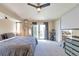 Bright main bedroom featuring a ceiling fan, projector, and balcony access at 14058 E Temple Dr, Aurora, CO 80015