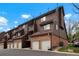 Exterior view of townhome with brick and wood siding and private garages at 832 S Vance St # F, Lakewood, CO 80226