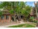 Brick apartment building with mature trees, manicured landscaping, and community outdoor access via stairs at 832 S Vance St # F, Lakewood, CO 80226