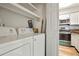Bright laundry room with shelves and a stackable washer and dryer next to the kitchen at 832 S Vance St # F, Lakewood, CO 80226