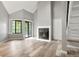 Bright living room features a fireplace, sliding glass door, modern flooring, and soaring vaulted ceilings at 832 S Vance St # F, Lakewood, CO 80226