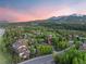 Scenic aerial view of a residential community nestled among evergreen trees with a mountain backdrop at sunset at 33 Broken Lance Dr # 207S, Breckenridge, CO 80424
