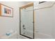 Clean bathroom featuring white tiled walls, bathtub with sliding glass door, and a framed piece of art at 33 Broken Lance Dr # 207S, Breckenridge, CO 80424
