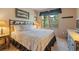 Comfortable bedroom with large windows offering treed views, a cozy bed, and rustic furnishings at 33 Broken Lance Dr # 207S, Breckenridge, CO 80424