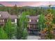 Multi-story residential building surrounded by lush green trees against a mountain backdrop at 33 Broken Lance Dr # 207S, Breckenridge, CO 80424