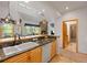 Bright kitchen with granite countertops, wood cabinets, and pass-through to the living area with stone fireplace at 33 Broken Lance Dr # 207S, Breckenridge, CO 80424
