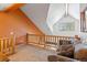 Upper level living area includes a vaulted ceiling, window, and wood railing at 33 Broken Lance Dr # 207S, Breckenridge, CO 80424