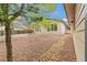 Spacious backyard showing the living space of the home, gravel landscaping and a brick pathway at 180 W 78Th Pl, Denver, CO 80221