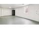 Unfinished basement with a small window, gray painted floors, and black storage cabinet at 180 W 78Th Pl, Denver, CO 80221