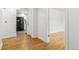 Hallway with hardwood floors leading to other rooms and a view of the kitchen at 180 W 78Th Pl, Denver, CO 80221