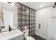 Modern bathroom with a patterned accent wall, white subway tile shower, and stylish sink vanity at 2244 S Lincoln St, Denver, CO 80210