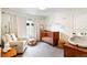 Cozy Bedroom with charming crib, soft chair, window, and cloud decals, creating a serene space at 2244 S Lincoln St, Denver, CO 80210