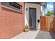 Welcoming front entrance with a modern gray door, brick accents, and a small potted plant for added charm at 2244 S Lincoln St, Denver, CO 80210