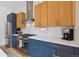 Bright kitchen boasts stainless appliances, blue cabinets with gold hardware, and white subway tile backsplash at 2244 S Lincoln St, Denver, CO 80210