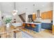 Open concept kitchen featuring a central island with seating, stainless steel appliances, and elegant pendant lighting at 2244 S Lincoln St, Denver, CO 80210
