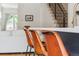 Close up view of kitchen island seating with stairs in background at 2244 S Lincoln St, Denver, CO 80210