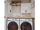 Efficient laundry room featuring modern side-by-side washer and dryer, cabinets, and counter space at 2244 S Lincoln St, Denver, CO 80210