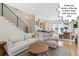 Bright, open living room flows to kitchen and dining area featuring modern staircase and hardwood floors at 2244 S Lincoln St, Denver, CO 80210