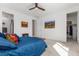 Bright bedroom with a ceiling fan, closet, neutral carpet, mountain painting, and blue bedding with colorful pillows at 2578 Gray Wolf Pl, Castle Rock, CO 80104