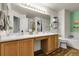Bright bathroom featuring double sinks, wood cabinets and a large mirror at 4251 S Blackhawk Cir # 3E, Aurora, CO 80014