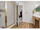 Bright bathroom featuring a glass enclosed shower and view to bedroom with stylish vinyl flooring at 4251 S Blackhawk Cir # 3E, Aurora, CO 80014