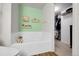 Well-lit bathroom featuring a soaking tub, decorative shelving, and access to a closet for storage at 4251 S Blackhawk Cir # 3E, Aurora, CO 80014