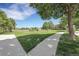 Well-maintained green space with mature trees, a walking path, and a glimpse of nearby homes under a bright blue sky at 4251 S Blackhawk Cir # 3E, Aurora, CO 80014