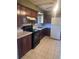 Cozy kitchen with dark wood cabinets, black appliances, and tile flooring at 606 Tennyson St, Denver, CO 80204