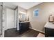Well-lit bathroom featuring dark cabinets, a marble countertop, and a glass shower at 671 Green Mountain Dr, Erie, CO 80516