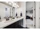 Bright bathroom showcasing a double vanity, and a doorway leading to the main bedroom at 671 Green Mountain Dr, Erie, CO 80516