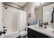Bright bathroom featuring a tub/shower combo, black fixtures, and modern white vanity at 671 Green Mountain Dr, Erie, CO 80516