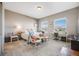 Cozy bedroom features carpeted floors, a bed, two chairs, and a view of the neighborhood at 671 Green Mountain Dr, Erie, CO 80516