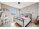 Bright bedroom with neutral walls, two windows, metal bed frame, vanity and guitar at 671 Green Mountain Dr, Erie, CO 80516