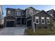 Charming two-story home with stone accents, a three-car garage, and well-manicured lawn at 671 Green Mountain Dr, Erie, CO 80516