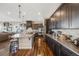 Bright, open kitchen with dark cabinets, island seating, and stainless steel appliances at 671 Green Mountain Dr, Erie, CO 80516