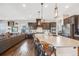 Modern kitchen with a large island, dark cabinetry, and seamless flow to the living space at 671 Green Mountain Dr, Erie, CO 80516
