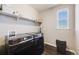Functional laundry room with modern front-load washer and dryer, shelving for storage and window at 671 Green Mountain Dr, Erie, CO 80516