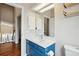 Bright bathroom showcasing a stylish blue vanity and white cabinets for ample storage at 7035 S Flower Ct, Littleton, CO 80128